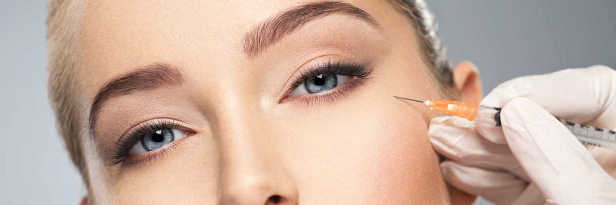 Woman getting cosmetic injection of botox in cheek