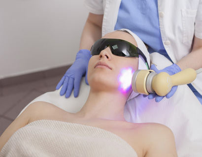 Face skin care. Woman getting facial laser treatment