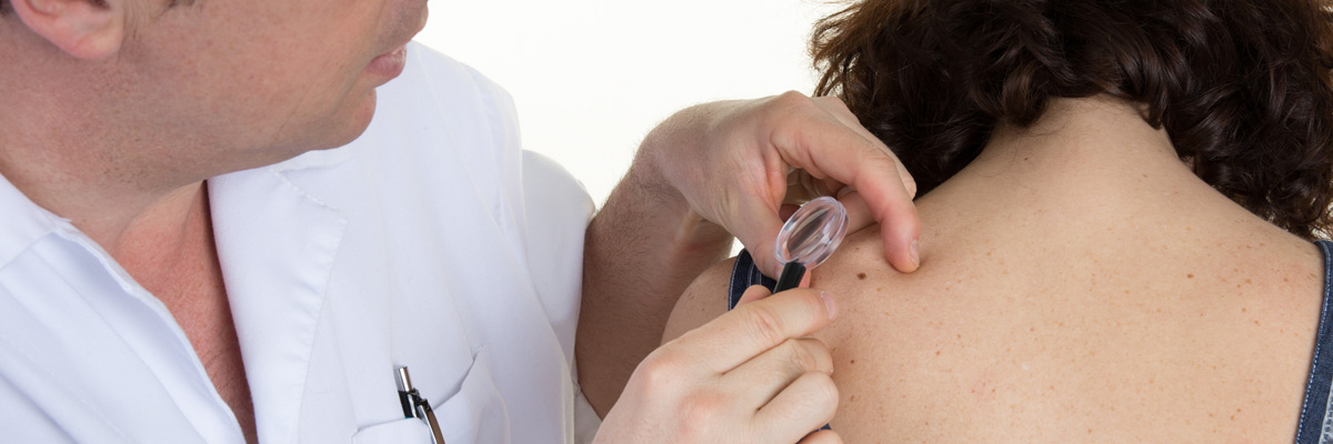 Young woman's back being examined at a dermatologists
