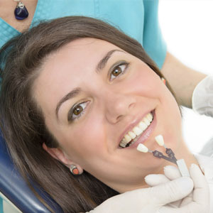 A dentist showing porcelain teeth to patient