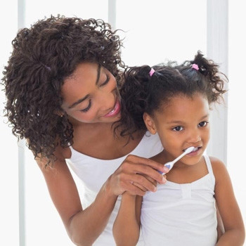 Mother and daughter brushing teeth