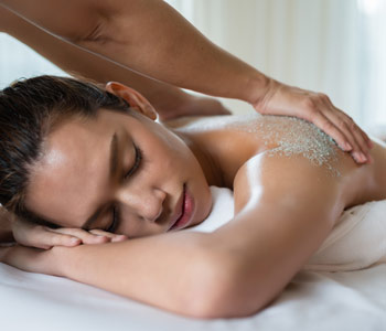 Young beautiful woman having salt scrub massage