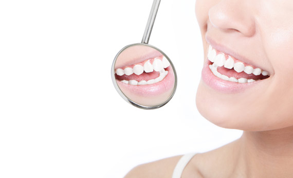 ealthy woman teeth and a dentist mouth mirror