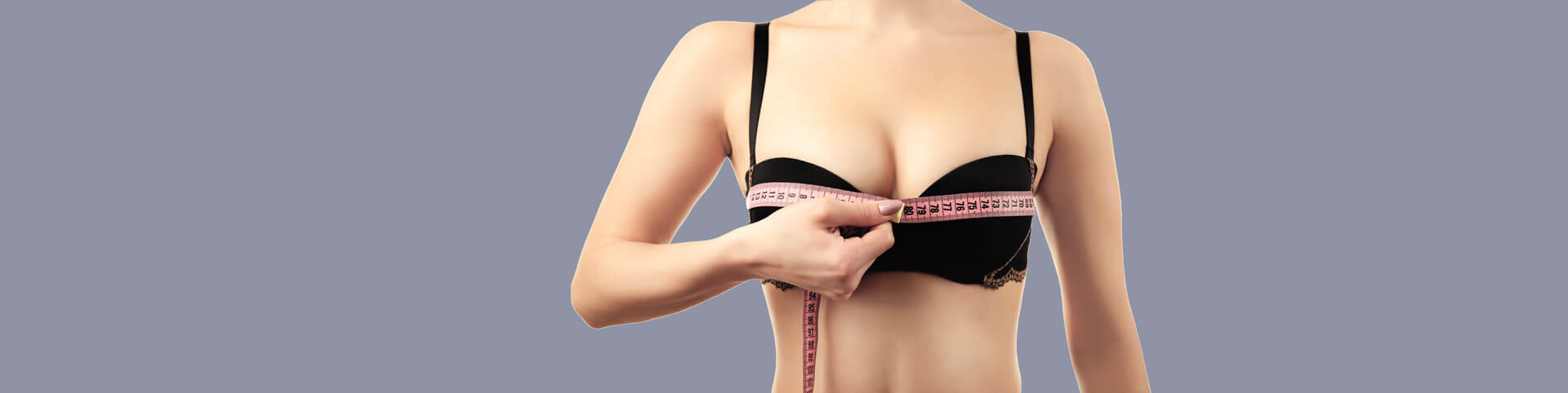 Closeup of young woman measuring size of her bust using a measuring tape
