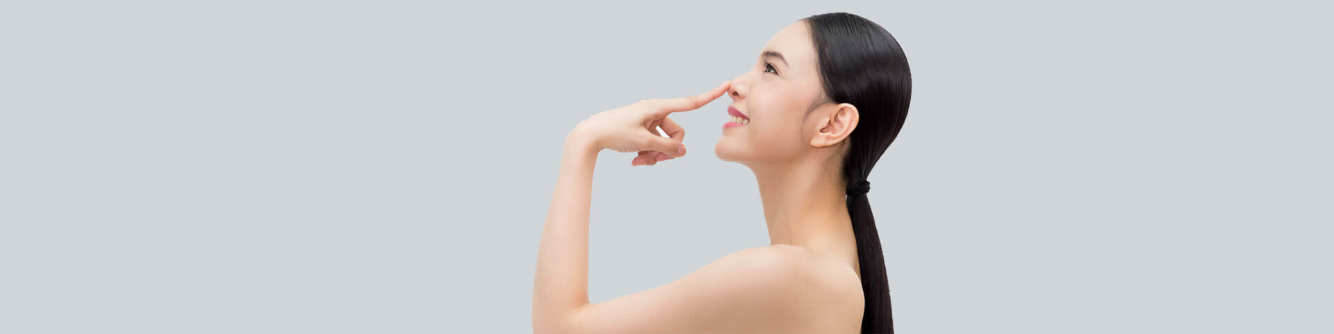 Young attractive woman touching her nose with fingertip