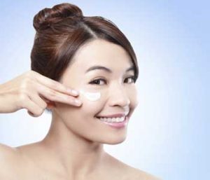 Woman apply cream on her face