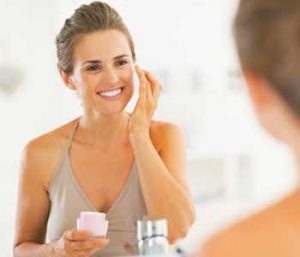 Woman apply cream on a fac
