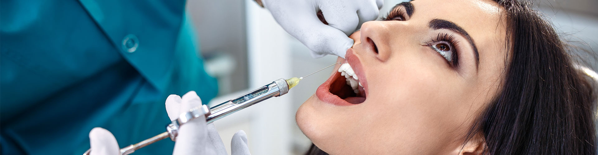 Cropped view of a female patient receiving dental treatment