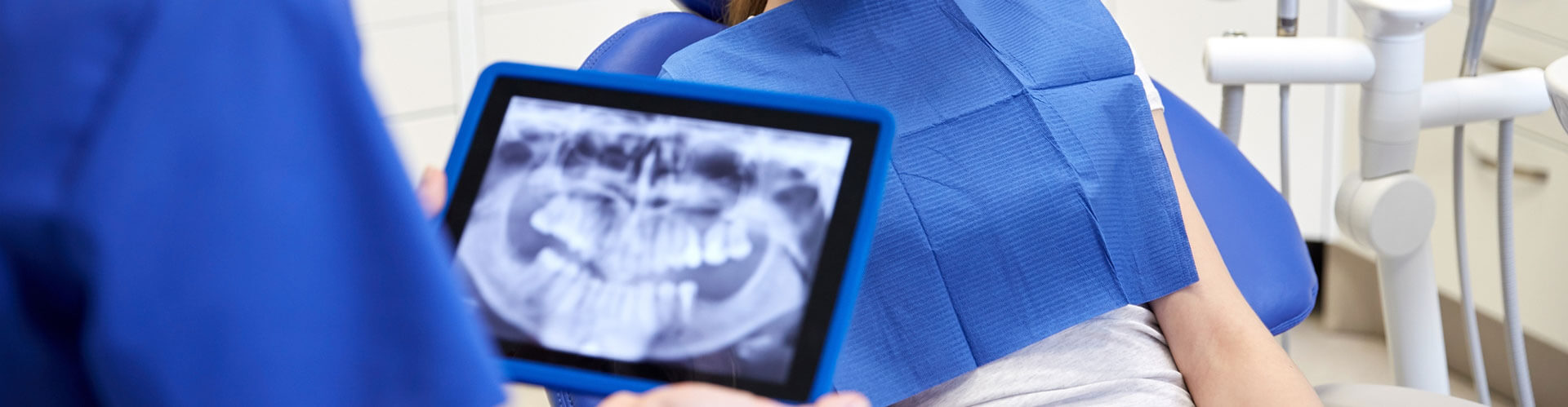 Cropped view of Dentist looking at x-ray on tablet pc