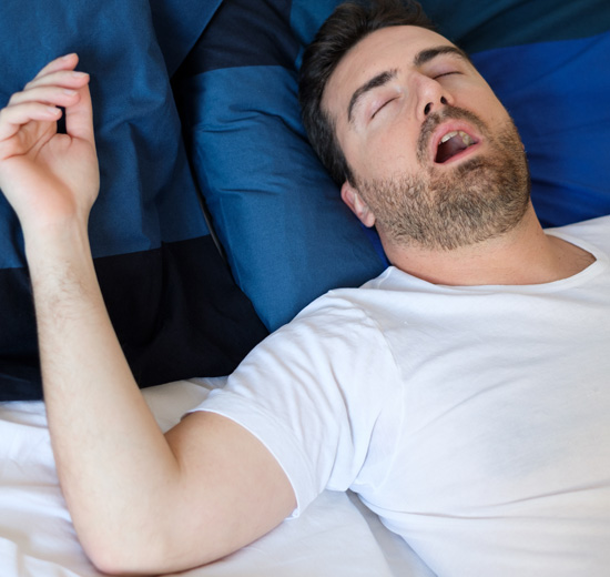 Man in bed suffering for sleep apnea syndrome
