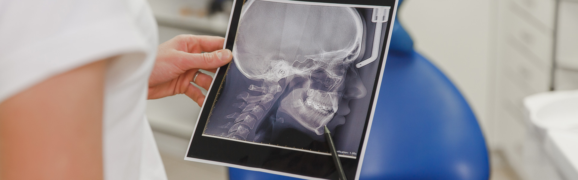 The female dentist holds an X-ray photo
