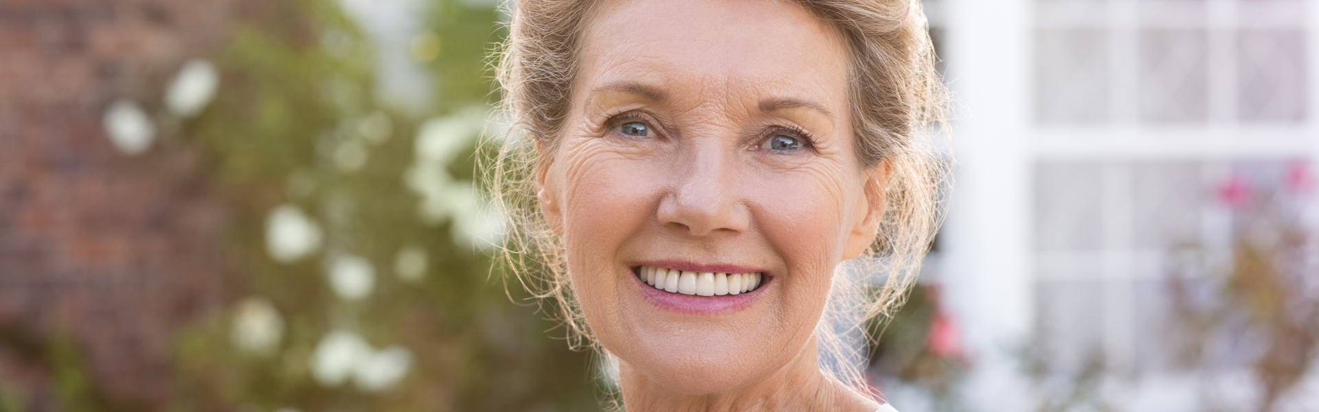 Happy senior woman standing outside.