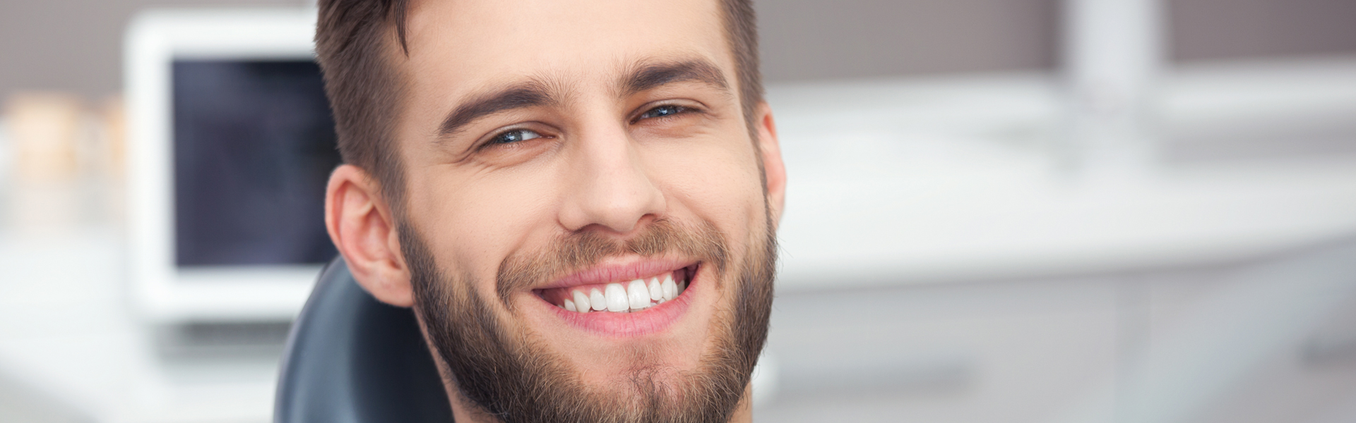 Happy patient in dental chair.