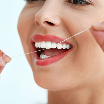 Young woman cleaning teeth with dental floss,