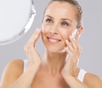 Elderly Woman Looking at her Face on the mirror