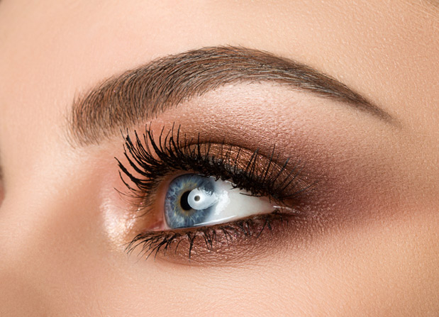 Close-up of woman eye with beautiful brown smokey eyes makeup